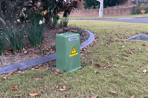 small green electrical box in yard|green electricity box outside house.